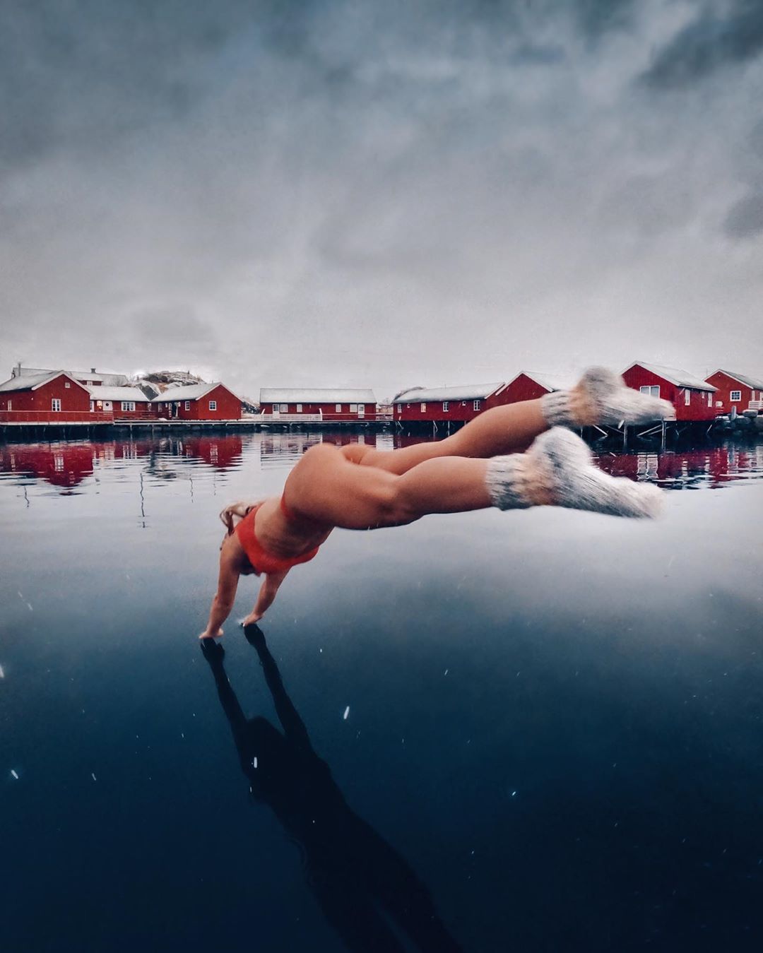 Девушка ныряет в ледяную воду в носках и купальнике